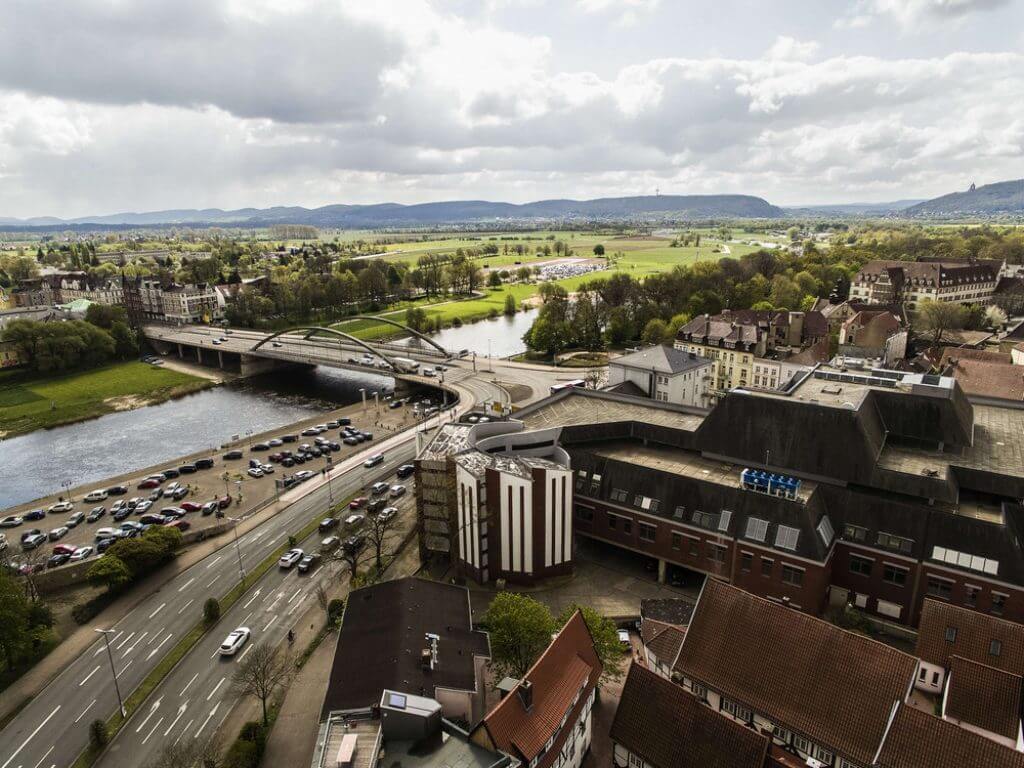 Das Geschäftshaus Wesertor in Minden mit Blick auf die Weser und die Brücken im Hintergrund.