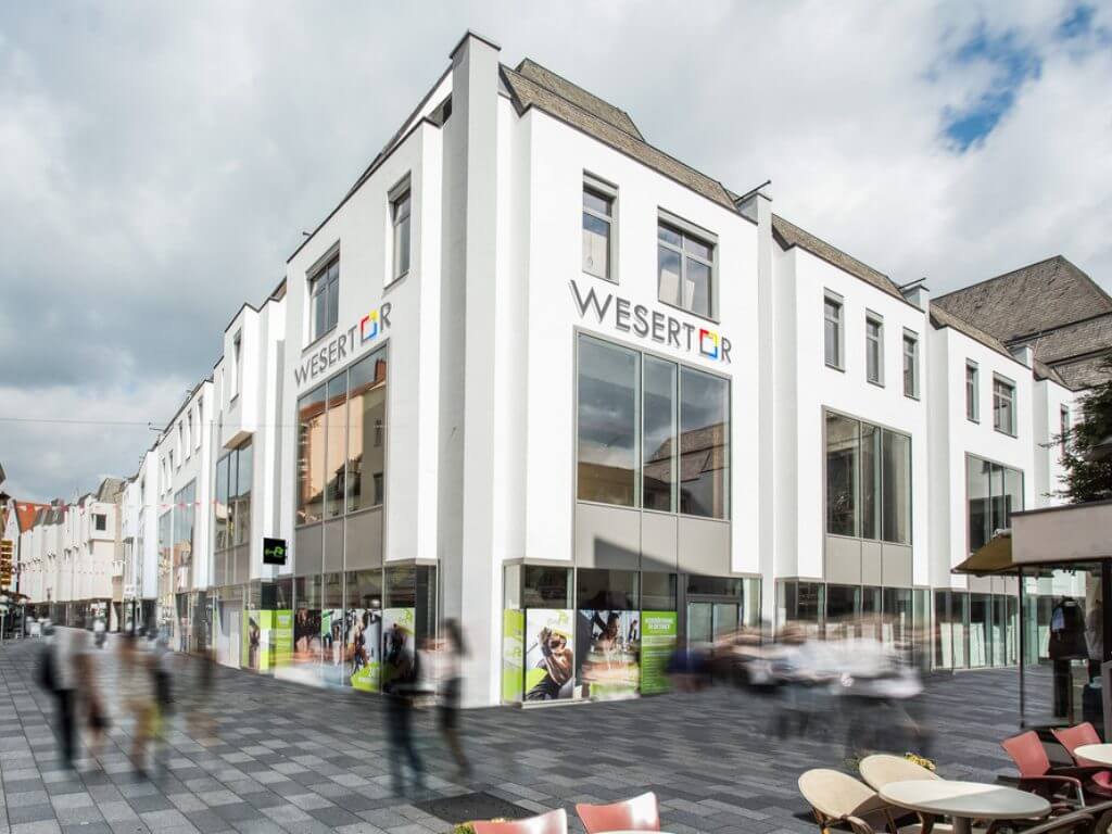 Das moderne Geschäftshaus Wesertor in Minden mit großen Fenstern und weißer Fassade.