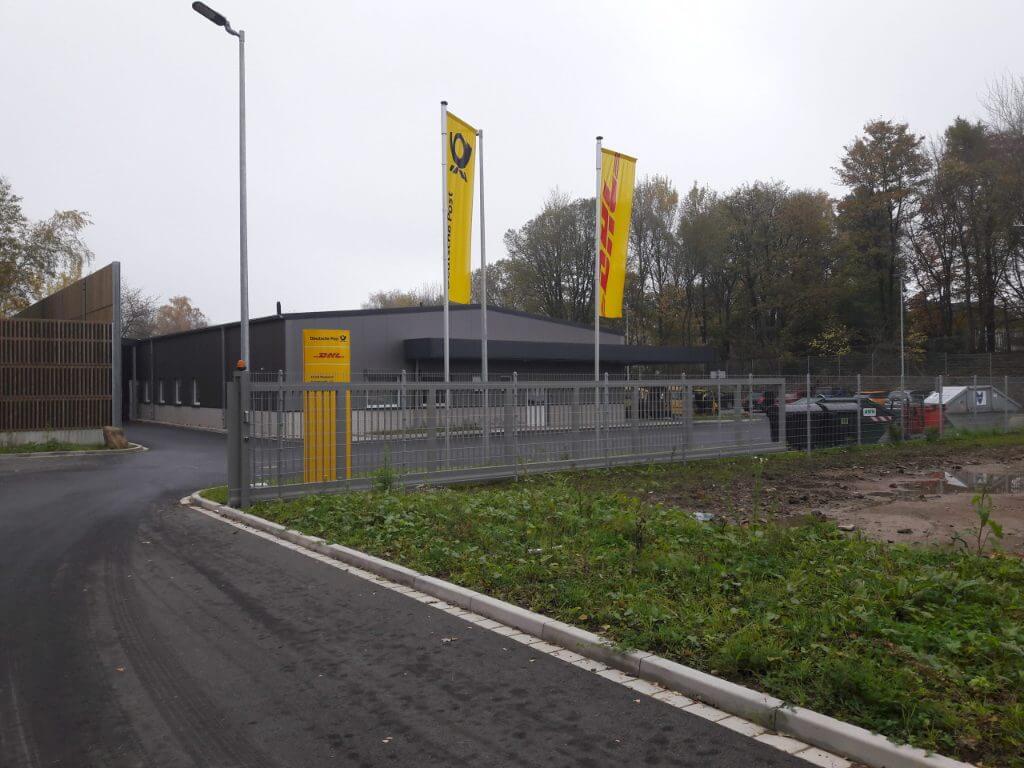 Modernes Gewerbegrundstück in Wuppertal mit Gebäuden und Flaggen von Deutsche Post und DHL.