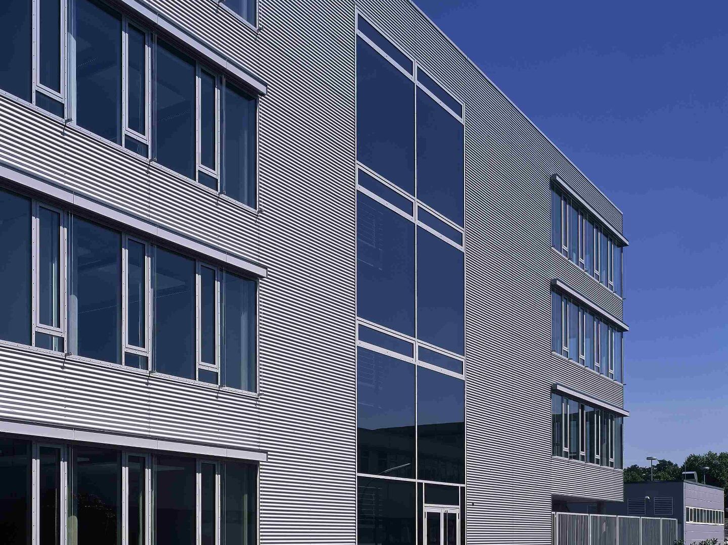 Fassadenansicht des Büro- und Gewerbeparks Kamp-Lintfort, ein hochwertiges Bauprojekt der Hellmich Gruppe mit moderner Architektur und großflächigen Fensterfronten.