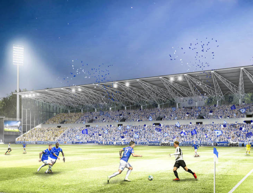 Spielfeld und Zuschauer im Darmstädter Stadion mit Bauplänen für neue Tribüne
