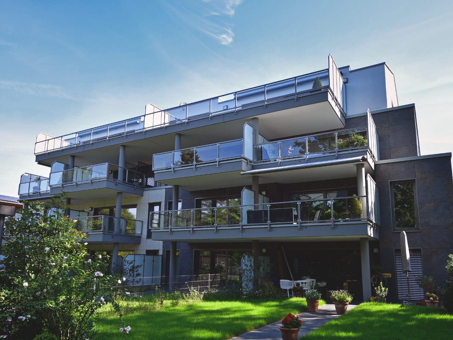 Modernes Wohngebäude in Dinslaken an der Voerderstraße, errichtet von Hellmich Bau mit großzügigen Balkonen und grünem Vorgarten.