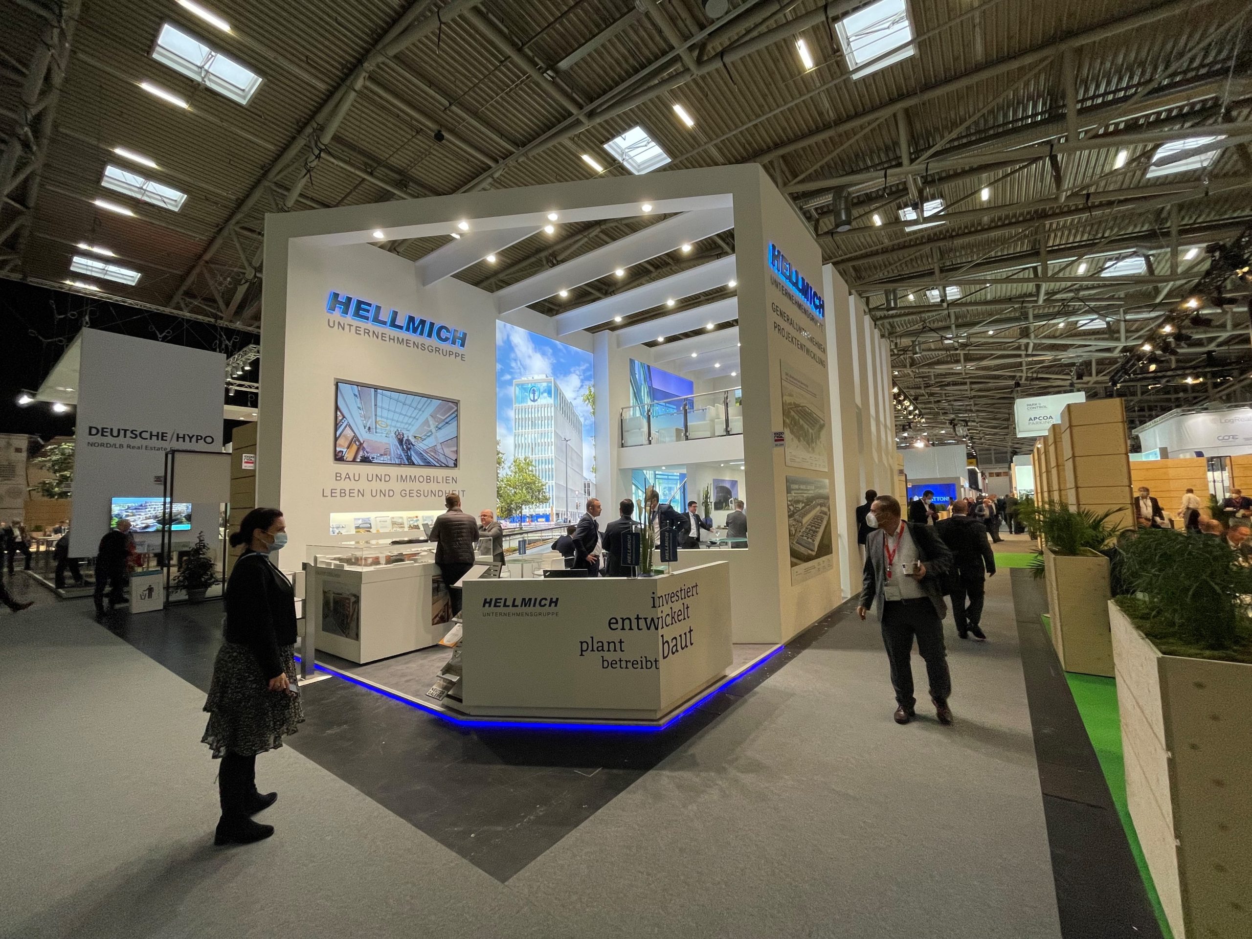 Messestand der Hellmich Unternehmensgruppe auf der Expo Real 2022 mit Besuchern und Informationsständen.
