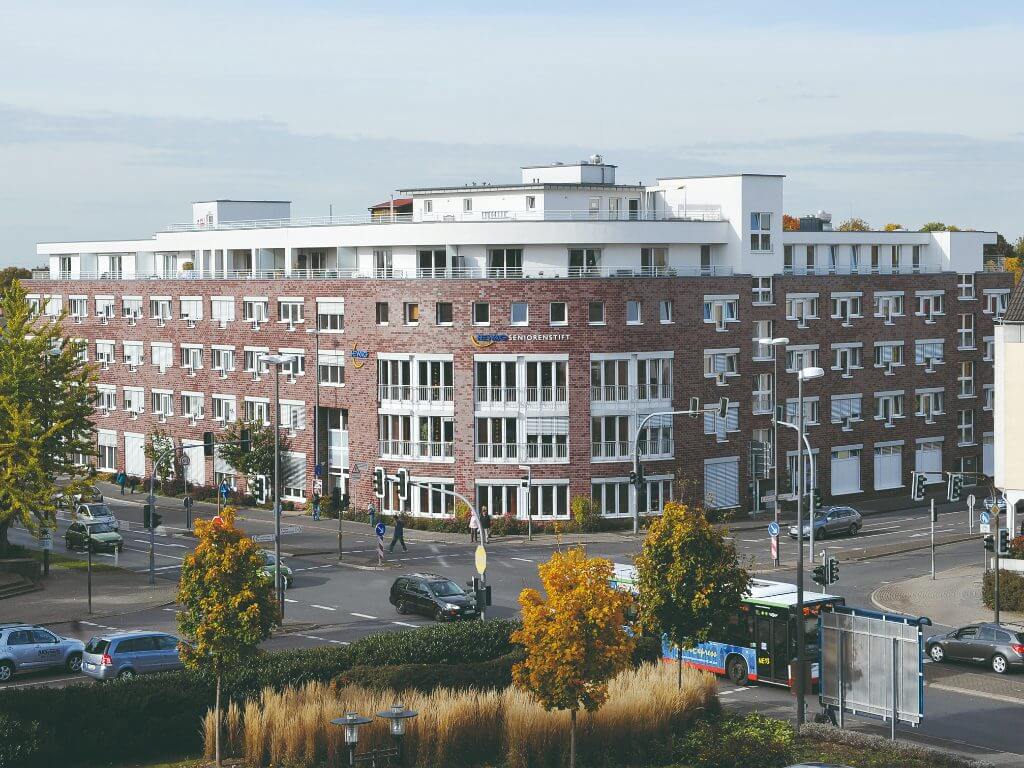 Außenansicht des HEWAG Seniorenstifts Langenfeld mit moderner Architektur an einer Straßenkreuzung