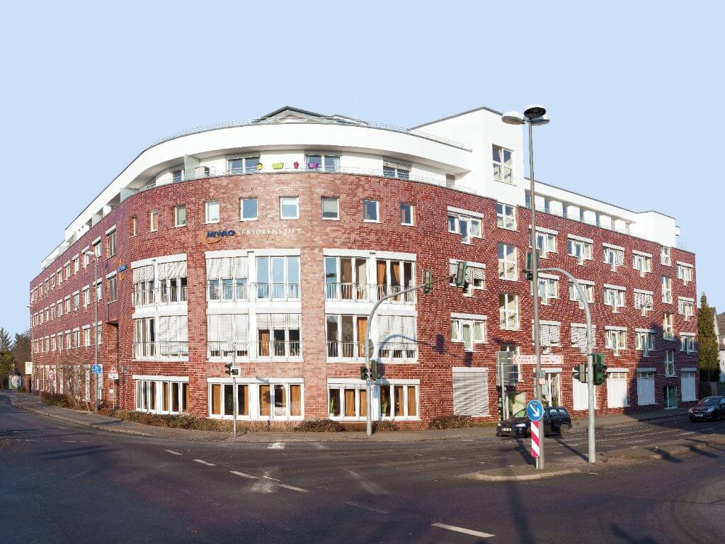 Blick auf die moderne Fassade des HEWAG Seniorenstifts in Langenfeld bei sonnigem Wetter.