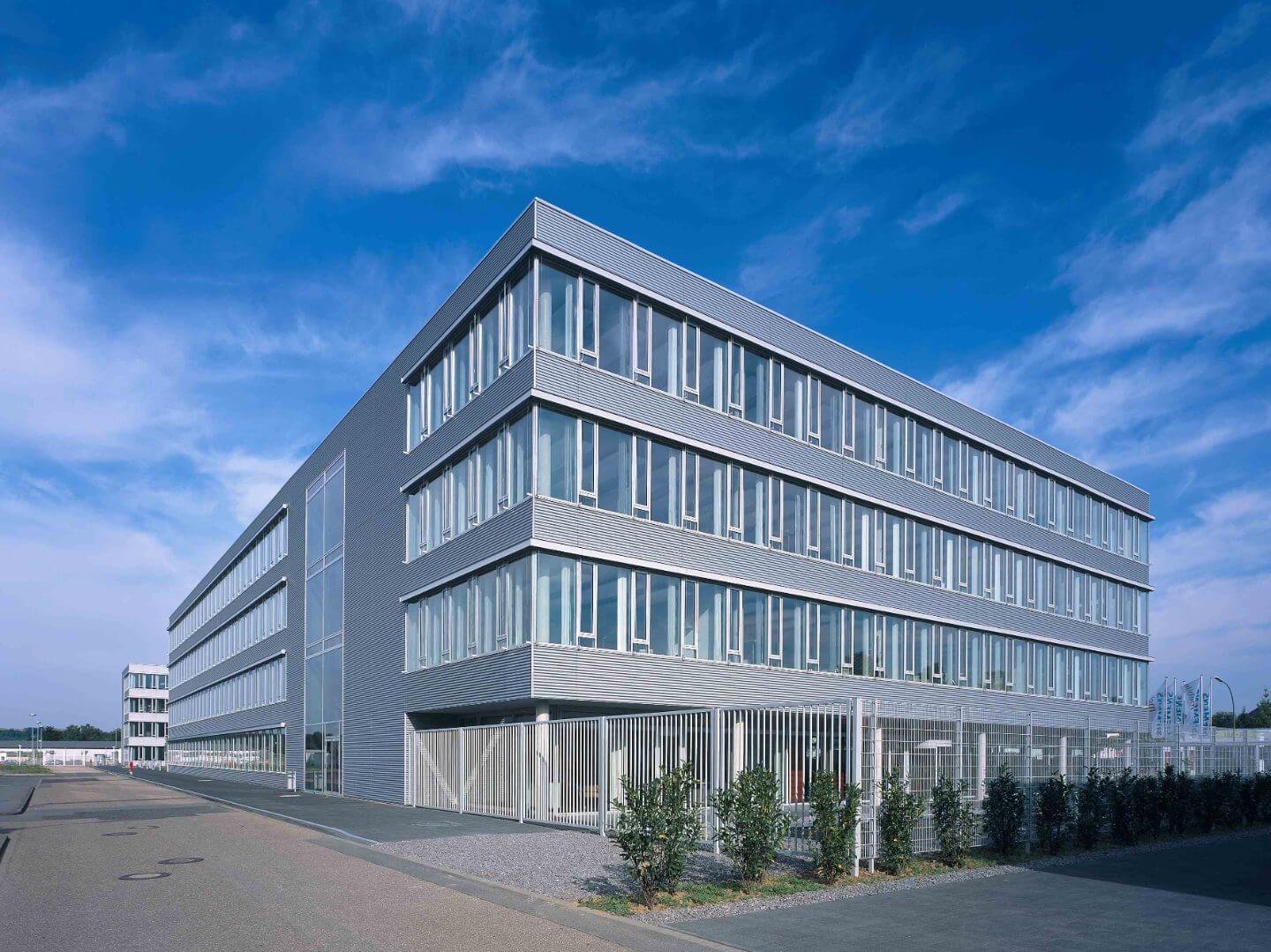 Modernes Büro- und Gewerbegebäude des Kamp-Lintfort Parks, realisiert von der Hellmich Gruppe, bei Tageslicht unter klarem Himmel.