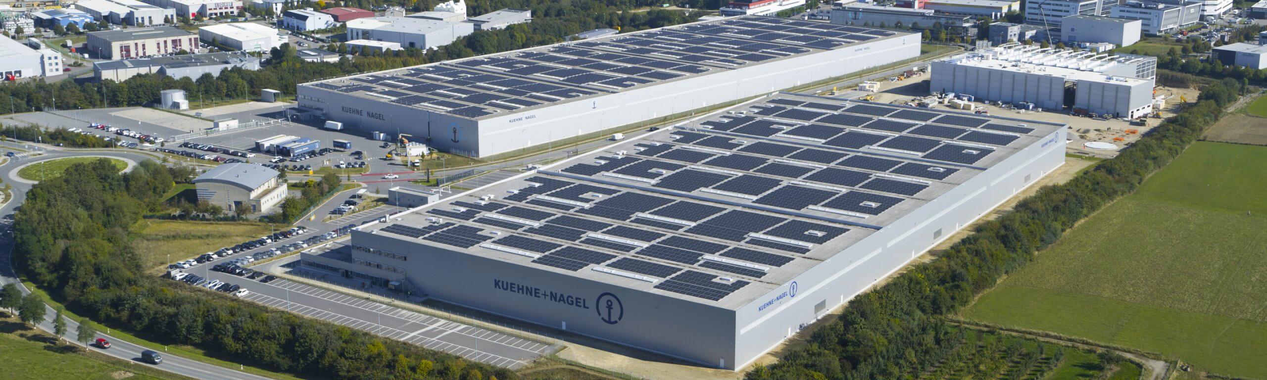 Luftaufnahme der Kühne + Nagel Logistikhalle mit zahlreichen Solarpanels auf dem Dach.