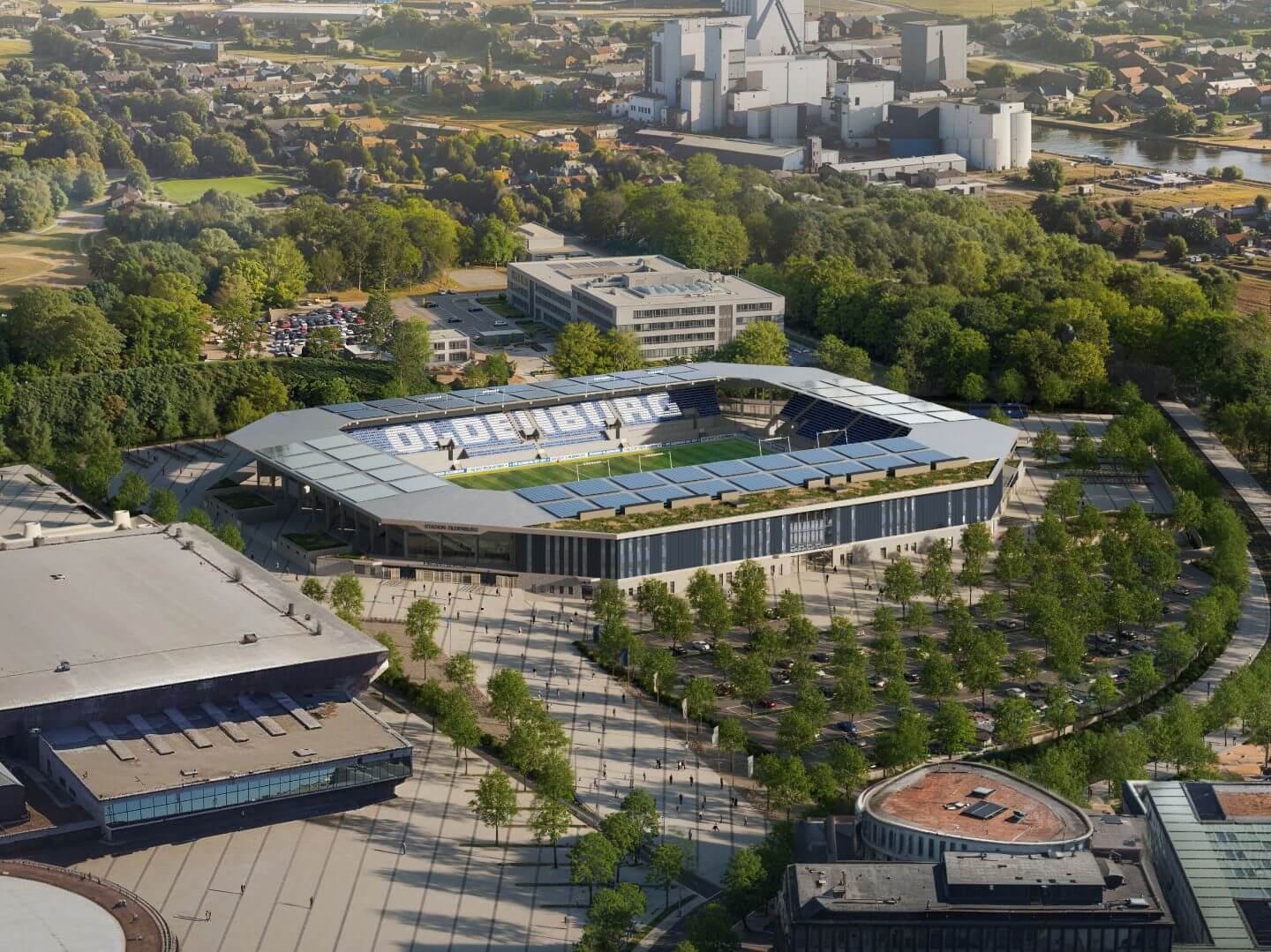 Vogelperspektive auf das moderne Stadion Oldenburg mit Solarpanelen auf dem Dach und umliegender Parkanlage.