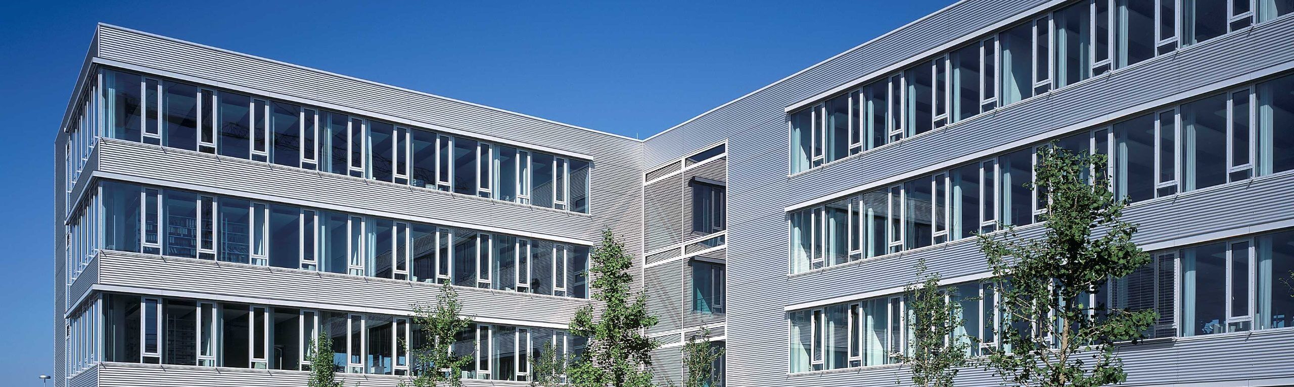 Fassade eines modernen Bürogebäudes im Gewerbepark Kamp-Lintfort unter klarem Himmel.