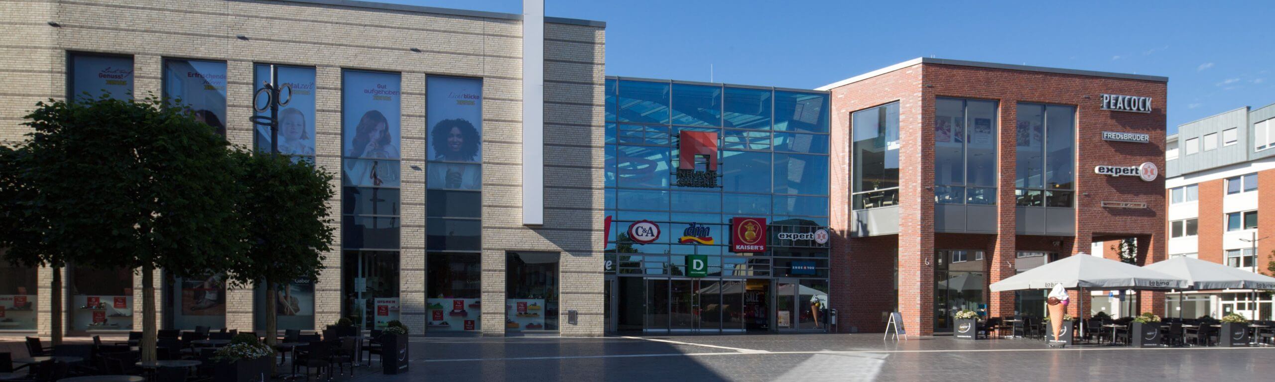Eingangsbereich der Neutor Galerie mit Schaufenstern und Logos von Einzelhändlern und Gastronomie.