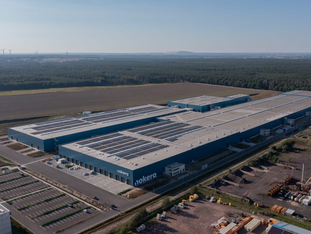 Vogelperspektive auf das große Nokera Fabrikgebäude in Stegelitz mit Solaranlagen auf dem Dach.