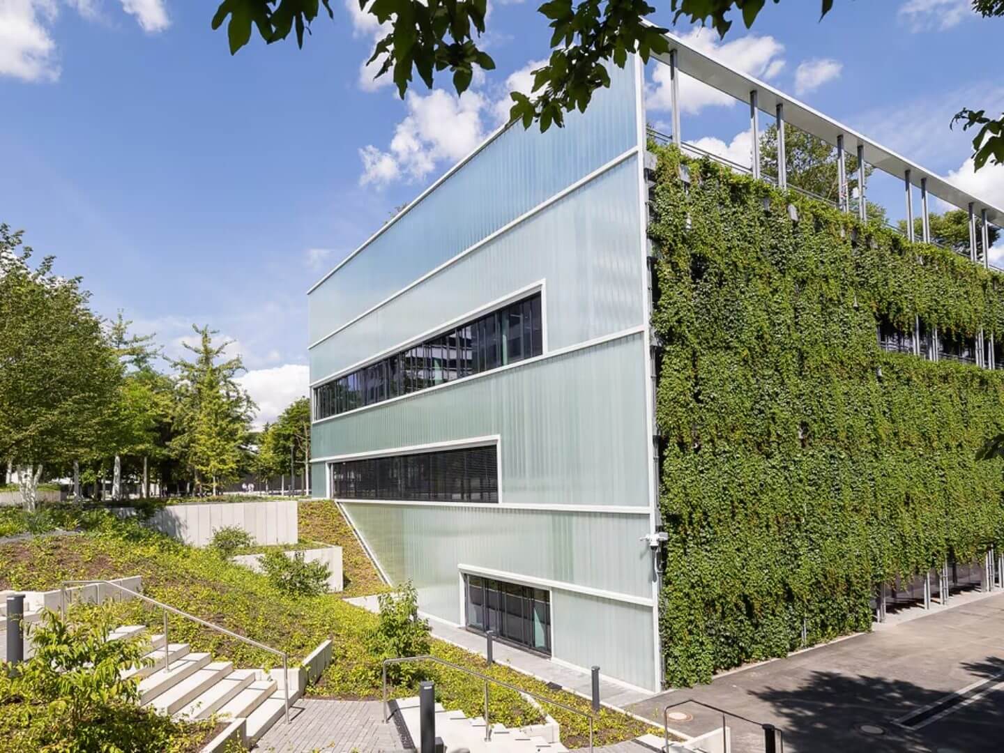 Architektonisch modernes Gebäude mit transluzenter Fassade und grüner Pflanzenwand als Teil des WILO Health Cube Bauprojekts der Hellmich Gruppe. Architektonisch modernes Gebäude mit transluzenter Fassade und grüner Pflanzenwand als Teil des WILO Health Cube Bauprojekts der Hellmich Gruppe.